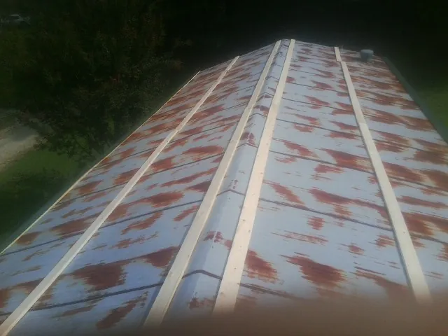 Rusted metal roof panels with new wood purlins before replacement — Storm Damage Roof Repair in Greene by Roofing Brothers